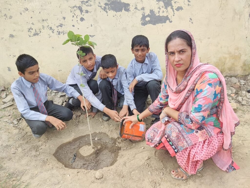 Students and a teacher planting a young tree on the school campus.